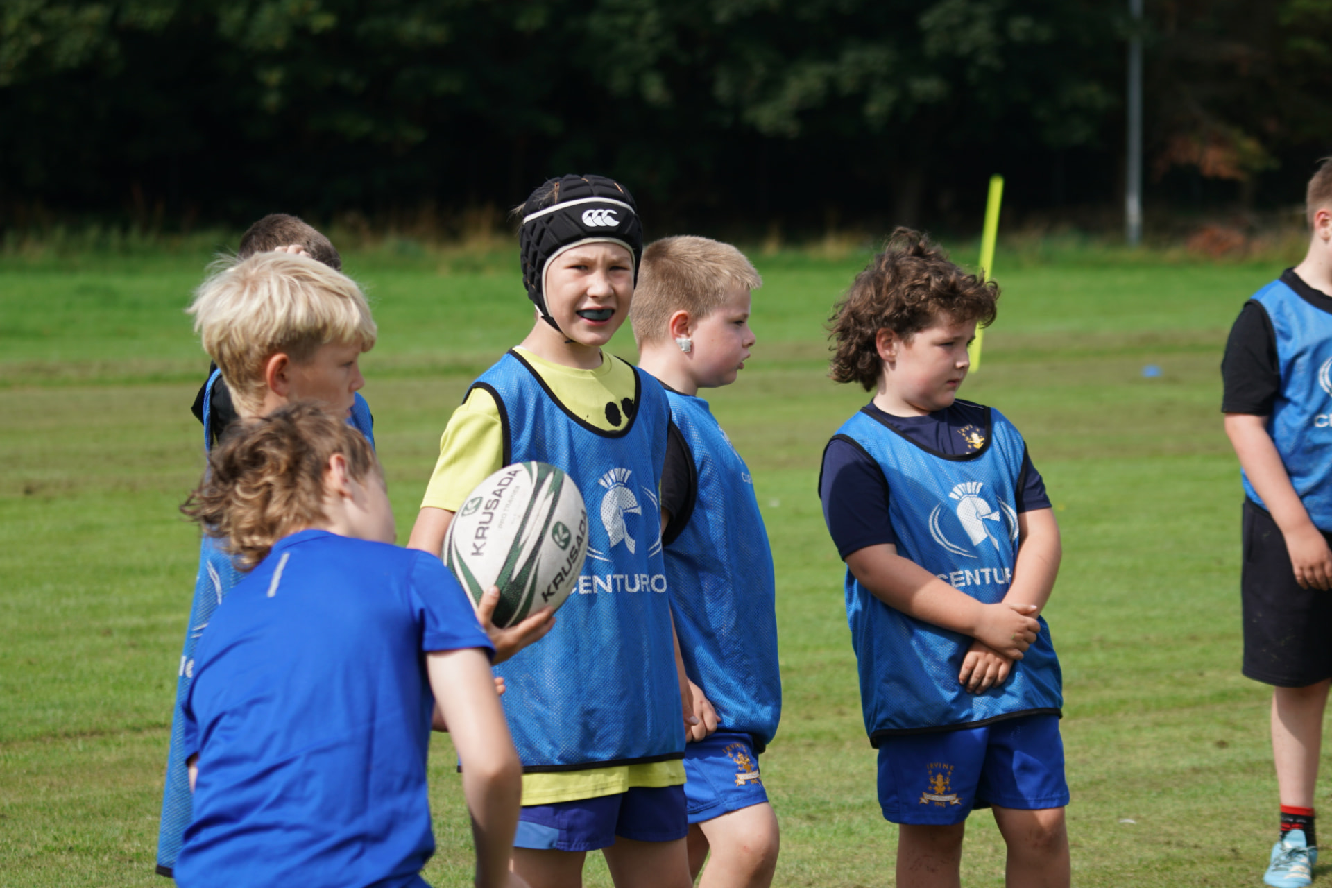 Junior rugby players in blue bibs during a training session